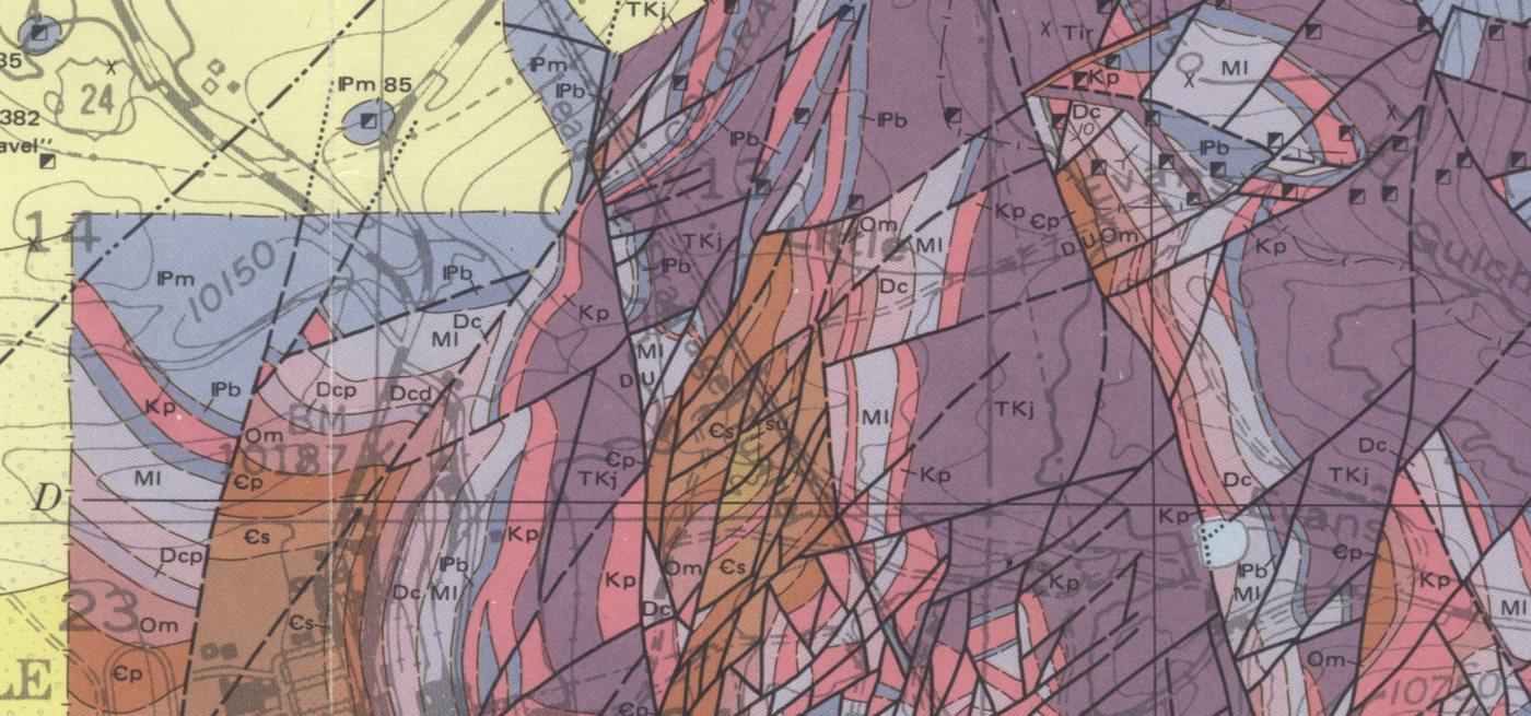 Geologic map showing faulted bedrock units, formation contacts, and fault traces across a mineralized mountain district
