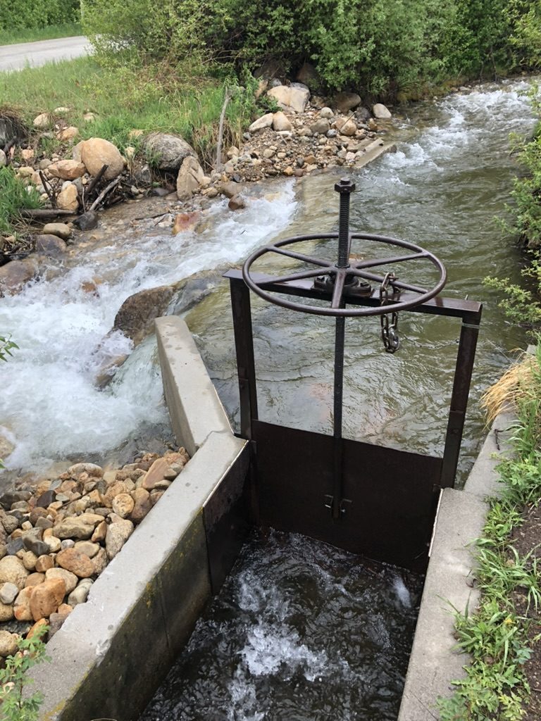 Diversion headgate with a hand wheel controlling flow on a Colorado creek